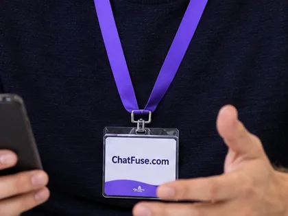 Two colleagues holding phones and wearing ChatFuse.com lanyards